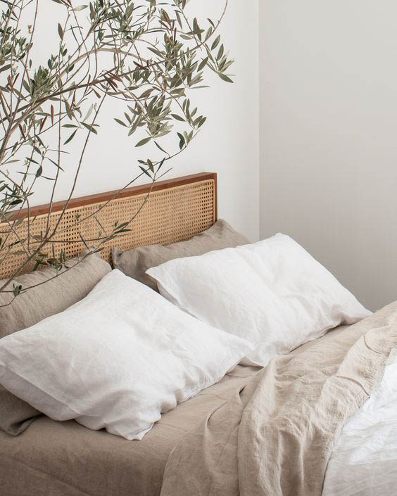 habitación con textiles de lino y rama de olivo decorando